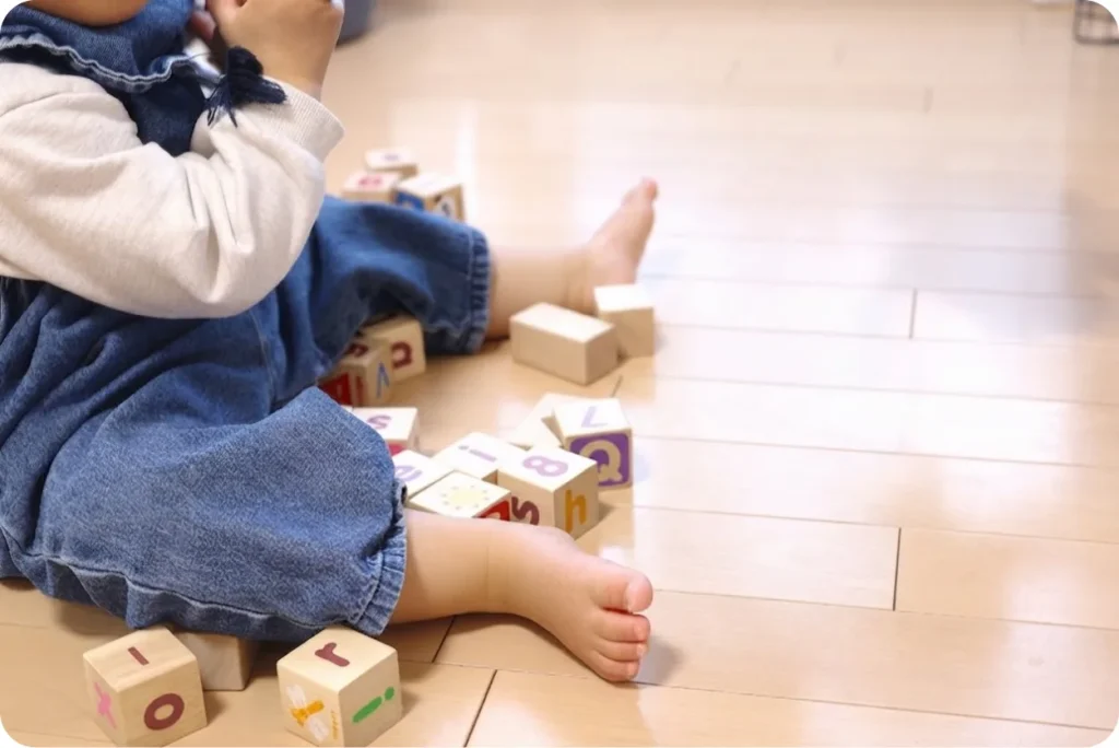 床で積み木遊びをする子ども